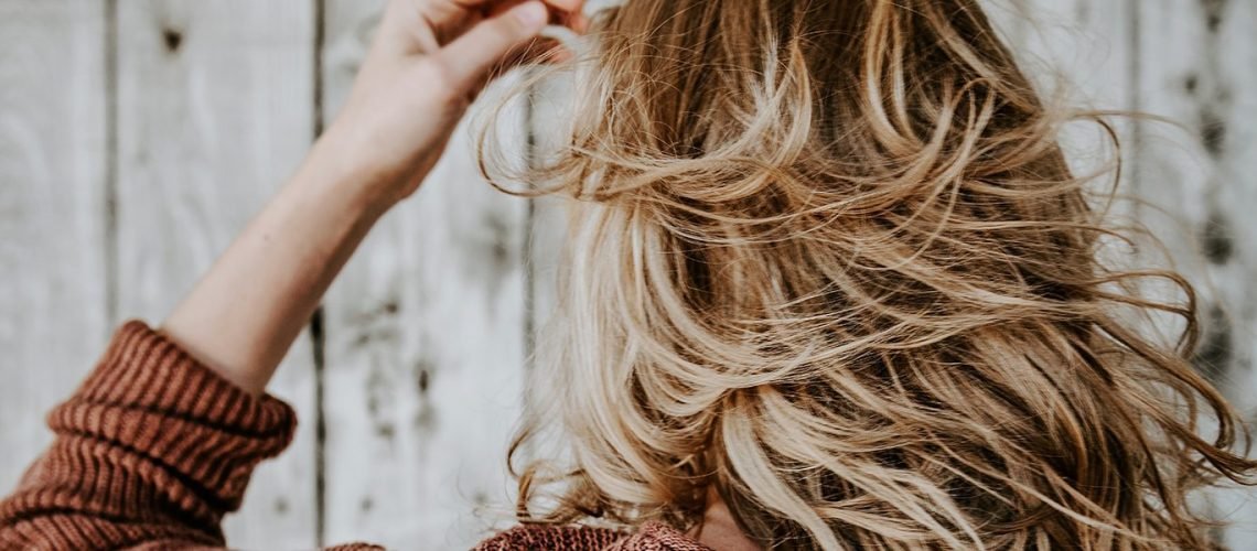 Stylist consulting with a client to assess hair type and health at Nasrin Salon